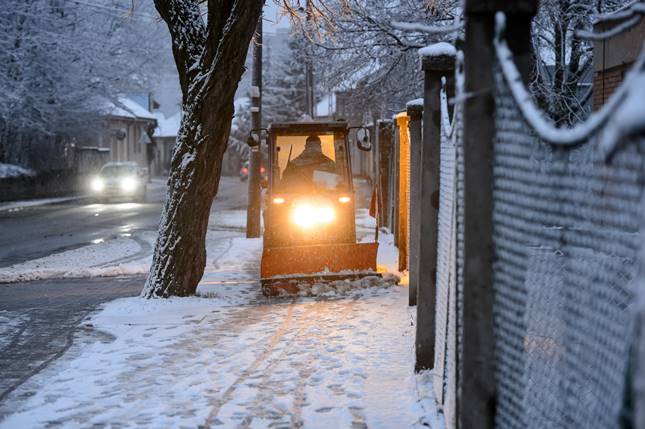 Munkagéppel takarítják a havas járdát Salgótarjánban 2021. január 25-én