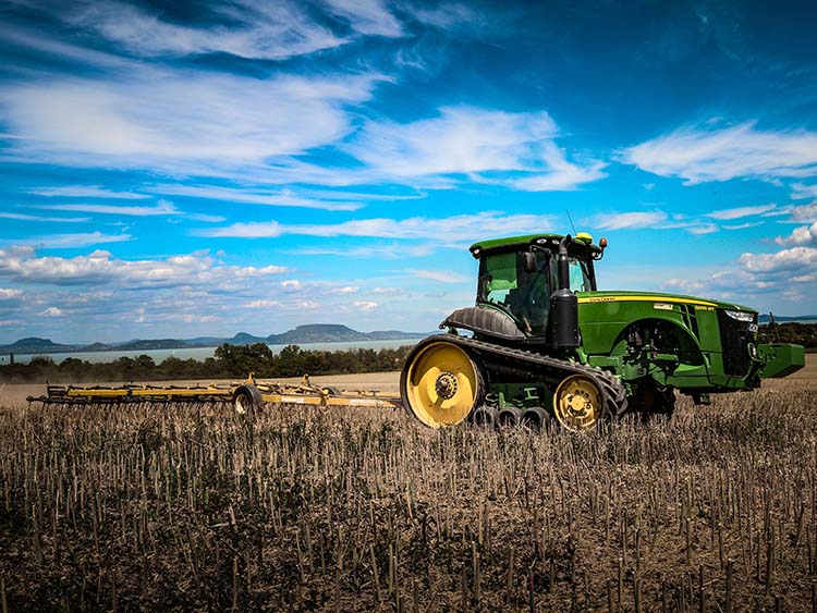 John Deere hevedertalpas traktor a szántóföldön