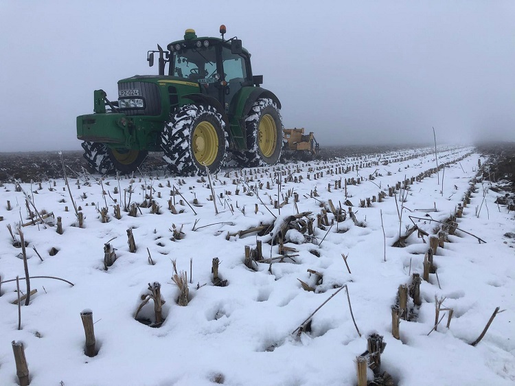 talajmunka a hóban John Deere traktorral