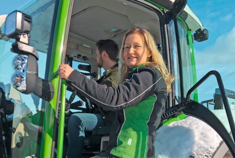 Christine Hain, értékesítési tanácsadó egy zöld traktorban